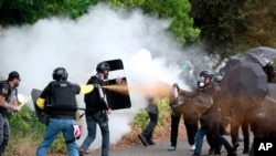 Members of the far-right group Proud Boys and anti-fascist protesters spray bear mace at each other during clashes between the politically opposed groups on Aug. 22, 2021, in Portland, Ore.