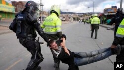 La policía detiene a un hombre durante las continuas protestas contra el gobierno provocadas por los aumentos de impuestos propuestos sobre los servicios públicos, el combustible, los salarios y las pensiones en Bogotá, Colombia, el lunes 28 de junio.