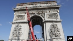 Cranes operate at the Arc de Triomphe in Paris, Tuesday, Aug.24, 2021. The "L'Arc de Triomphe, Wrapped" project by late artist Christo and Jeanne-Claude will be on view from, Sept.18 to Oct. 3, 2021. The famed Paris monument will be wrapped in 25…