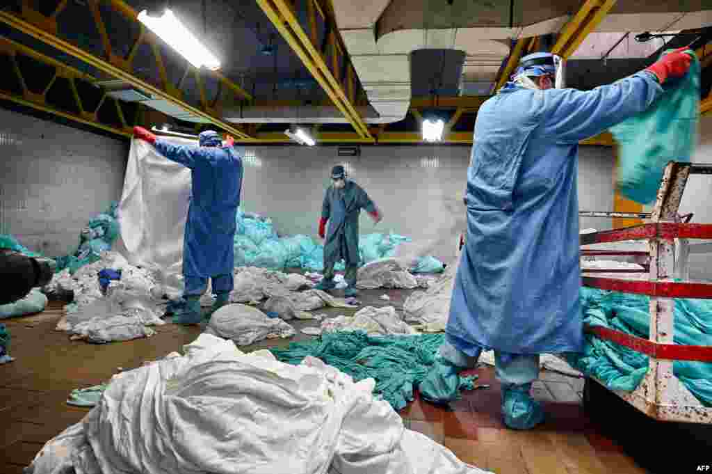 Workers handle dirty laundry from the COVID-19 zone, in the laundry room of the Mexican Institute of Social Security (IMSS), in Mexico City.