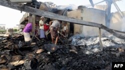 FILE - Yemeni men inspect the damage at a factory allegedly targeted by Saudi-led coalition's airstrikes in the Red Sea town of Hodeida, July 27, 2018.