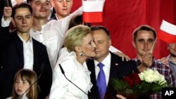 Incumbent President Andrzej Duda is hugged by his wife, Agata Kornhauser-Duda, in Pultusk, Poland, July 12, 2020. 