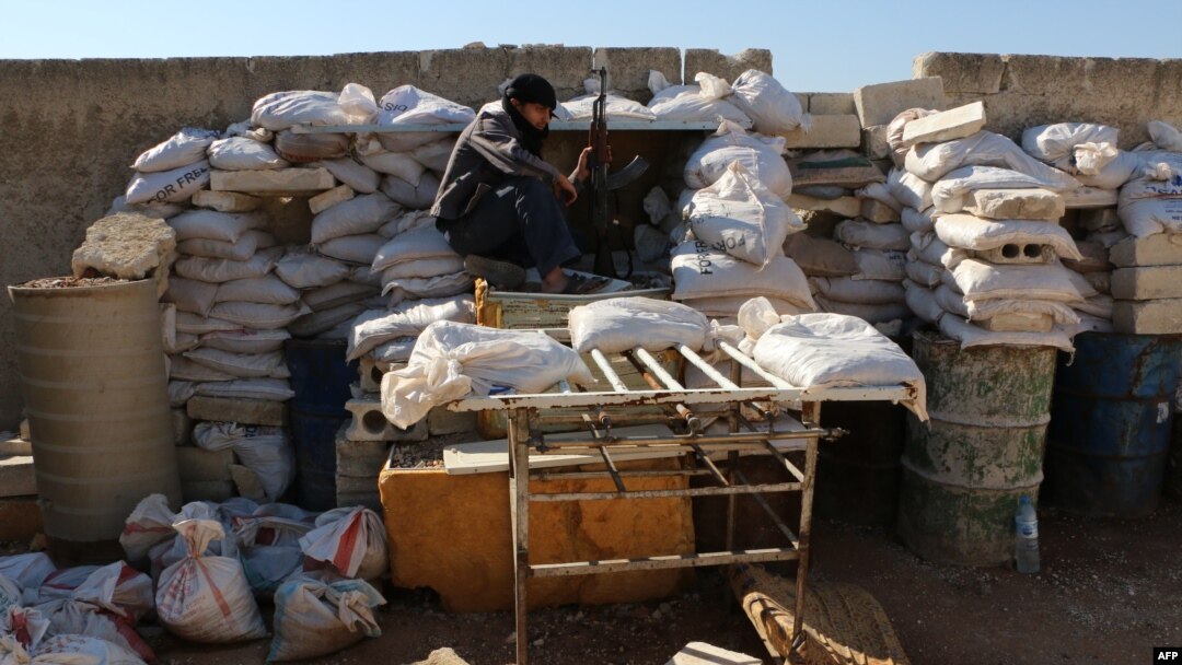 FILE - A rebel fighter from the Free Syrian Army sits on a barricade as he holds a position on a front line in the northern city of Aleppo, Oct. 1, 2014. 