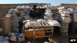 FILE - A rebel fighter from the Free Syrian Army sits on a barricade as he holds a position on a front line in the northern city of Aleppo, Oct. 1, 2014. 