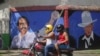 FILE - A motorcyclist rides past a mural of Nicaraguan President Daniel Ortega, left, and revolutionary hero Cesar Augusto Sandino during general elections in Managua, Nicaragua, Nov. 7, 2021. 