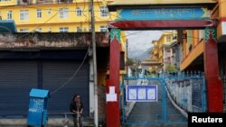 Seorang pria mengisi embernya dengan air di luar Biara Tantrik Gyuto yang ditutup selama sebulan di tengah ketakutan merebaknya virus corona di Dharamsala, India, 12 Maret 2020. 