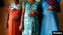 FILE - Surrogate mothers (L-R) Daksha, 37, Renuka, 23, and Rajia, 39, pose for a photograph inside a temporary home for surrogates provided by Akanksha IVF centre in Anand town, about 70 km (44 miles) south of the western Indian city of Ahmedabad.