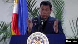 Philippine President Rodrigo Duterte interacts with reporters during a news conference upon his arrival from a four-day state visit to China at the Davao International Airport in Davao city, Philippines, Oct. 21, 2016.