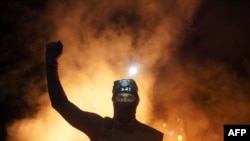 A protester holds his fist in the air during a protest against racial injustice and police brutality early in the morning on Aug. 23, 2020, in Portland, Oregon.