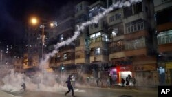 Para demonstran berlarian menghindari gas air mata yang ditembakkan oleh pasukan keamanan dari markas polisi Shum Shui Po, Hong Kong, Rabu malam (14/8). 