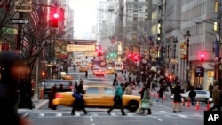 FILE - Vehicles and pedestrians make their way down Fifth Avenue in New York City, Dec. 22, 2005.