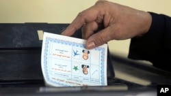 A woman casts her vote during the first day of the presidential election at a polling station in Cairo, Egypt, March 26, 2018.