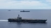 In this photo provided by U.S. Navy, the USS Ronald Reagan (CVN 76, front) and USS Nimitz (CVN 68, rear) Carrier Strike Groups sail together in formation, in the South China Sea, July 6, 2020. 