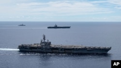 ຮູບ​ພາບ​ກຳ​ປັ່ນ​ບັນ​ທຸກ​ເຮືອ​ບິນ​ລົບ​ສະ​ຫະ​ລັດ USS Ronald Reagan (CVN 76, front) ແລະ​ກຳ​ປັ່ນ USS Nimitz (CVN 68, rear) ຂອງ​ກຸ່ມ​ໂຈມ​ຕີ ທີ່ທະ​ເລ​ຈີນ​ໃຕ້ ວັນ​ທີ 6 ກໍ​ລະ​ກົດ 2020. 
