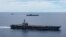 In this photo provided by U.S. Navy, the USS Ronald Reagan (CVN 76, front) and USS Nimitz (CVN 68, rear) Carrier Strike Groups sail together in formation, in the South China Sea, July 6, 2020. 