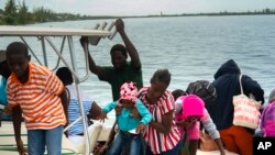 Varias personas evacuadas de Cayo Sweeting, Gran Bahama, por el peligro de inundaciones, llegan a puerto antes del huracán Dorian. Agosto 31 de 2019. AP/Ramón Espinosa.