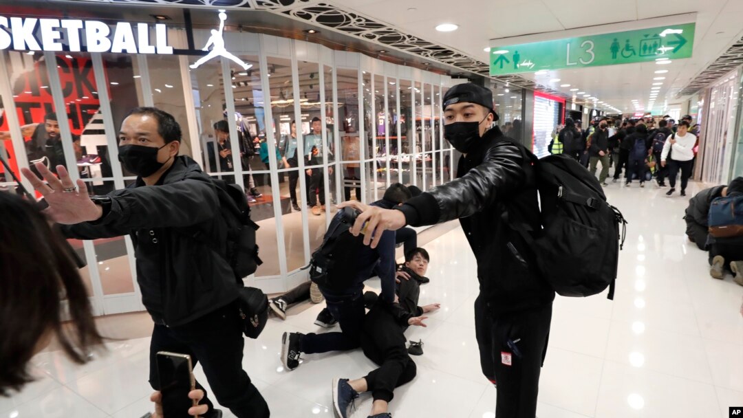 Um polícia à paisana usa gás pimenta numa manifestação num centro comercial de Hong Kong, 28 Dezembro, 2019