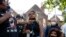FILE- A woman addresses Minnesota Governor Tim Walz, right, during a demonstration, June 1, 2020, in St. Paul, Minn. Protests continued following the death of George Floyd, who died after being restrained by Minneapolis police officers on May 25.