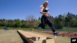 FILE - In this April 14, 2020 photo, Olympic pole vaulting silver medalist Sandi Morris runs on the vaulting pit she is building with her father in Greenville, S.C. The coronavirus crisis has forced many athletes to be creative to continue their training. (AP Photo/John Bazemore)