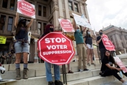 FILE - Voting rights activists gather during a protest against Texas legislators who are advancing a slew of new voting restrictions, in Austin, Texas, May 8, 2021.