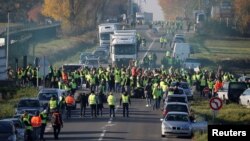 People wearing yellow vests, a symbol of a French drivers' nationwide protest against higher fuel prices, block the Paris-Brussels motorway in Haulchin, France, Nov. 17, 2018. 