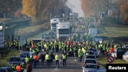 People wearing yellow vests, a symbol of a French drivers' nationwide protest against higher fuel prices, block the Paris-Brussels motorway in Haulchin, France, Nov. 17, 2018. 