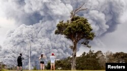 Residentes observan la expulsión de cenica del volcán Kilauea en la Isla Grande de Hawái el martes, 15 de mayo, de 2018.