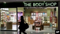 FILE - A woman passes a Body Shop cosmetics store at the airport in Frankfurt, central Germany, March 17, 2006. 