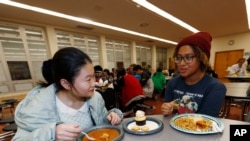 In this Jan. 27, 2017 photo, foreign exchange student Miaofan Chen, left, of Hefei, China, chats with Thandi Glick in Denver.