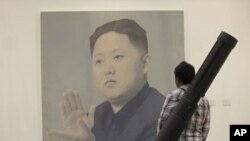 A man looks at a portrait of North Korean leader Kim Jong Un by Chinese artist Yan Lei at the China International Gallery Exposition 2012 in Beijing, April 13, 2012. 
