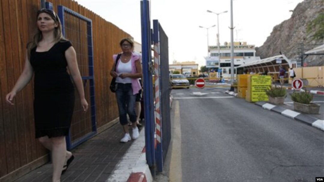 Dua warga melewati terminal Taba di kawasan Semenanjung Sinai Mesir, dekat kota perbatasan Eilat, Israel (18/8).