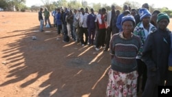 FILE - In this Sept. 16, 2008 file photo, Zimbabweans queue at Home Affairs offices in Musina, South Africa, close to the Zimbabwean border, to seek refugee status.