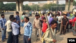 Kuli bangunan berkumpul di distrik bisnis Gurgaon dekat New Delhi, berharap mendapat pekerjan. (VOA/A. Pasricha)