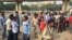Scores of daily wage workers wait at a major street intersection in the business hub of Gurgaon near New Delhi hoping to find work. (A. Pasricha/VOA)
