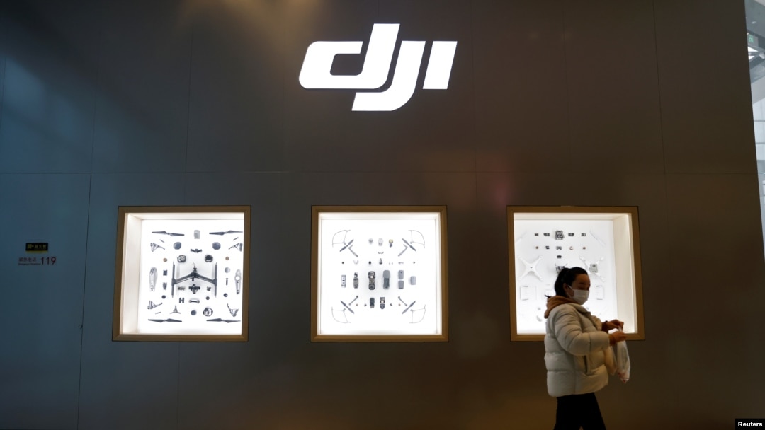 Seorang perempuan melewati toko produsen drone China, DJI, di dalam sebuah pusat perbelanjan di Beijing, 15 Desember 2021. (Foto: Carlos Garcia Rawlins/Reuters)