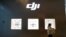FILE - A woman walks past a store of Chinese drone maker DJI inside a shopping mall in Beijing, Dec. 15, 2021. 