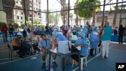 Trabajadores de la salud colocan dosis de la vacuna Sputnik V COVID-19 en el barrio 23 de Enero en Caracas, Venezuela, el 9 de junio de 2021.