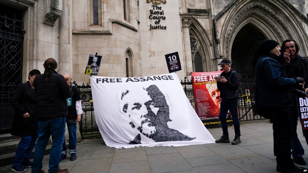 Sebuah spanduk yang bertuliskan dukungan terhadap pendiri WikiLeaks Julian Assange dipasang di luar gedung Pengadilan Tinggi London, pada 23 Oktober 2021. Spanduk tersebut dibentangkan menjelang pengadilan kasus ekstradisi Assange. (Foto: AP/Alberto Pezzali)
