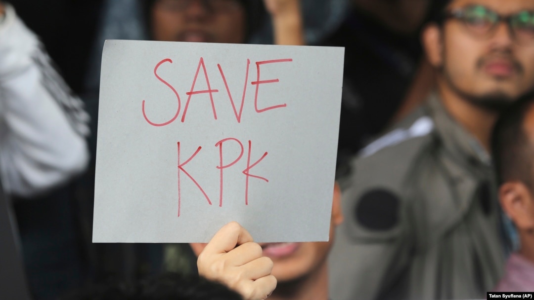 Seorang pendukung KPK mengacungkan poster dalam aksi protes penangkapan Wakil Ketua Komisi Pemberantasan Korupsi Bambang Widjojanto oleh polisi, di luar kantor KPK di Jakarta, Jumat, 23 Januari 2015. (Foto: AP/Tatan Syuflana)