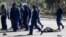FILE: A protester lies unconsciously on the ground after being beaten by police near Unity Square in Harare on August 16, 2019. 