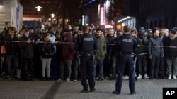 Travelers and bystanders are kept away by police outside the Duesseldorf, western Germany, main station after several people had been injured in an axe attack, March 9, 2017. 