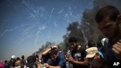 Des dizaines de bombes lacrymogènes tirées par les troupes israéliennes tombent sur des manifestants palestiniens à la frontière de la bande de Gaza avec Israël, vendredi 8 juin 2018. (Photo AP / Khalil Hamra)