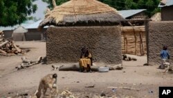 Une femme non identifiée est aperçue devant sa maison à Chibok, village d’où les combattants ont enlevé 276 lycéennes le 14 avril 2014, au Nigeria. Photo : 19 mai 2014.