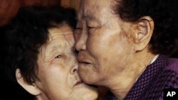 South Korean Lee Chun Hwa, right, gets a kiss from her North Korean sister Lee Chun Son before returning home after a separated family reunion meeting at the Diamond Mountain resort in North Korea, Feb. 22, 2014.