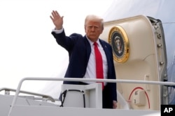 Presiden Donald Trump melambaikan tangan saat menaiki Air Force One dalam perjalanan menuju Florida di Bandara Internasional Harry Reid di Las Vegas, Sabtu, 25 Januari 2025. (Foto: AP)