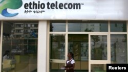 FILE - A woman walks past an office of Ethio Telecom, a state monopoly, in Ethiopia's capital, Addis Ababa, Nov. 9, 2015.