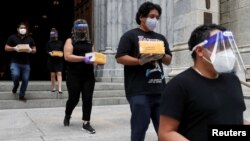 Organizers cover the boxed cremated remains of Mexicans who died from COVID-19 before a service at St. Patrick's Cathedral, July 11, 2020, in New York. The ashes were blessed before they were repatriated to Mexico.