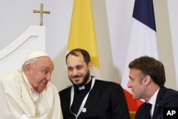 French President Emmanuel Macron, right, meets Pope Francis at the Ajaccio airport after the first papal visit ever to the French island of Corsica, Dec. 15, 2024.