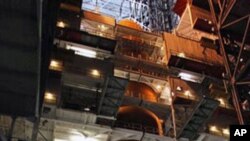 This image provided by NASA shows space shuttle Discovery with it's external fuel tank being worked on and examined in the Vehicle Assembly Building at NASA's Kennedy Space Center in Florida. NASA decided to delay the launch and allow the teams additional