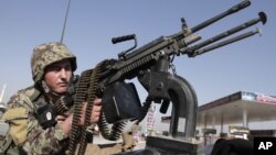 Afghan National army soldier takes on a weapon during a patrol near prayers gather for Eid al-Adha near a mosque in the outskirt of Jalalabad east of Kabul, Afghanistan, October 26, 2012. 